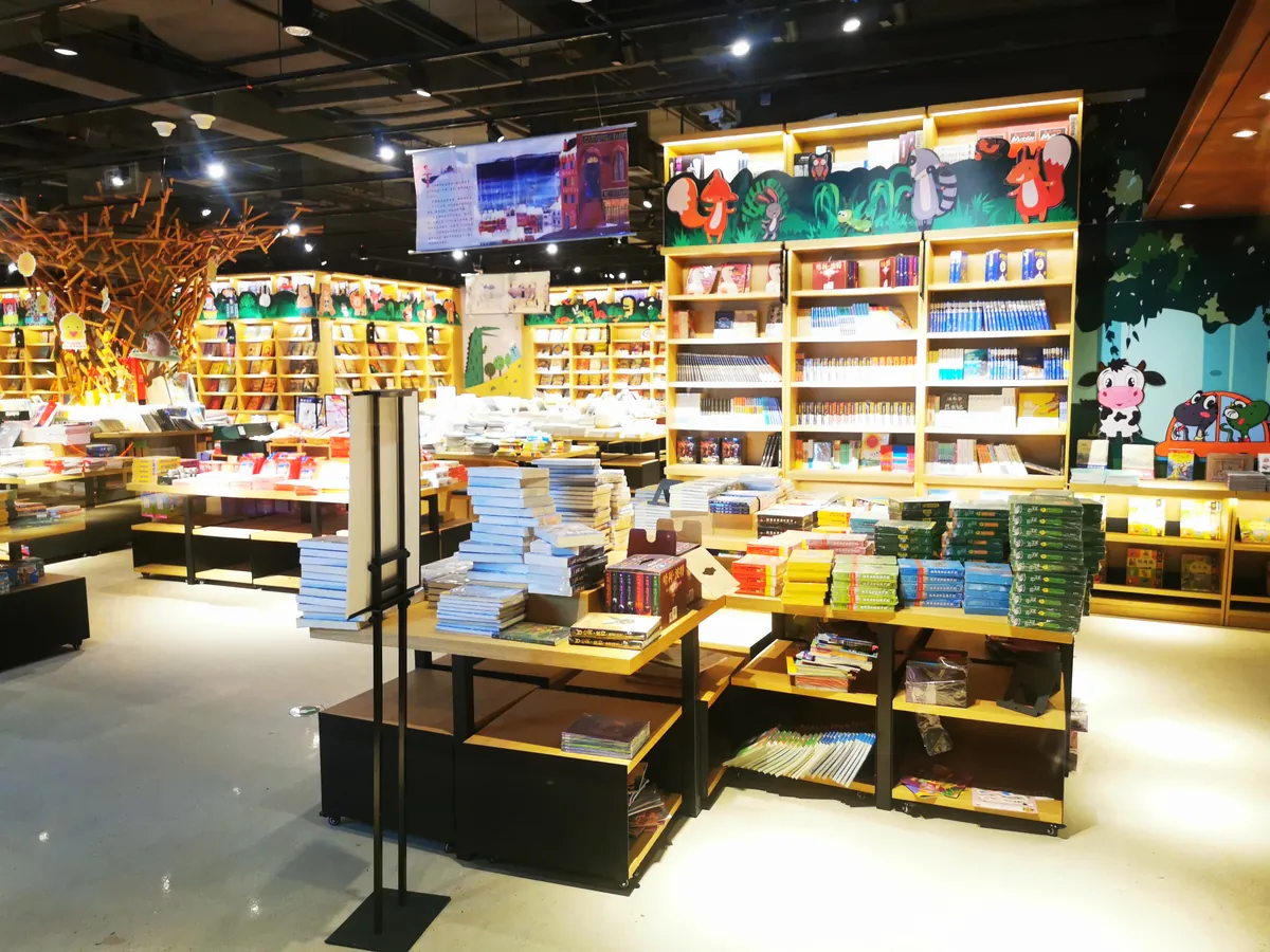 Cross-border retail showroom displaying imported books and consumer goods, with a live broadcast screen — the in-market retail touchpoint for cross-border brands.