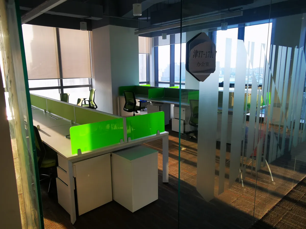 GOODSINFINITE Tianjin office (津 YT-1701) inside the Tianjin free-trade zone: glass-partition workstations with city skyline view, where the China entry team sits.