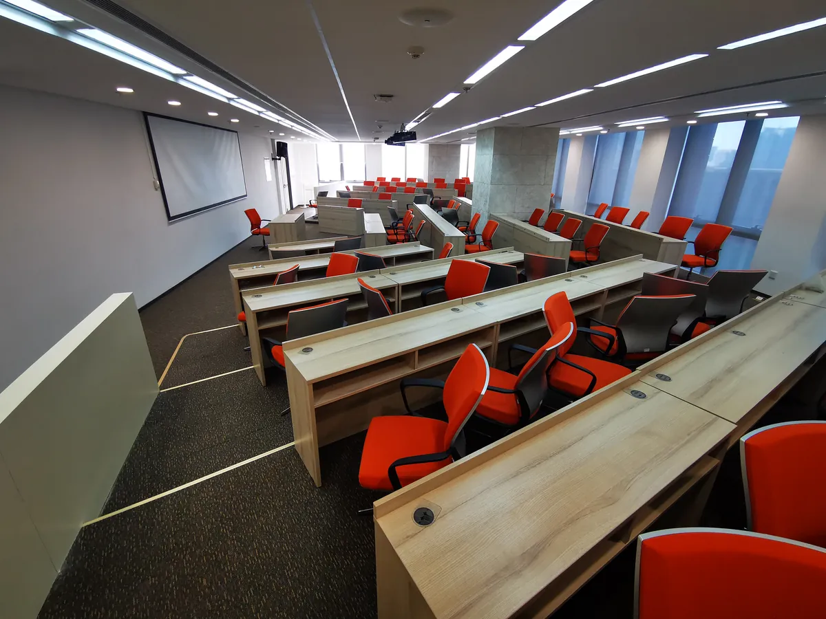 Tiered lecture room with orange chairs for in-house training on China customs 1210 declaration, GACC registration for foreign food brands, and live-commerce retention ops.